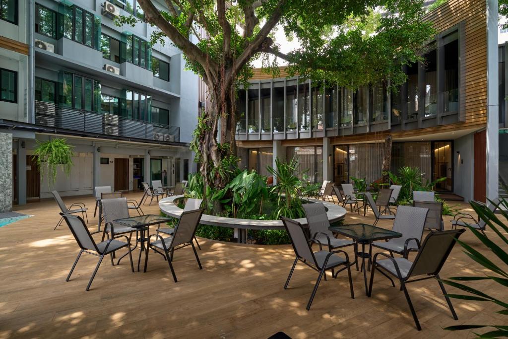 a courtyard with tables and chairs in a building at Red Door Samsen Hotel, Bangkok in Bangkok