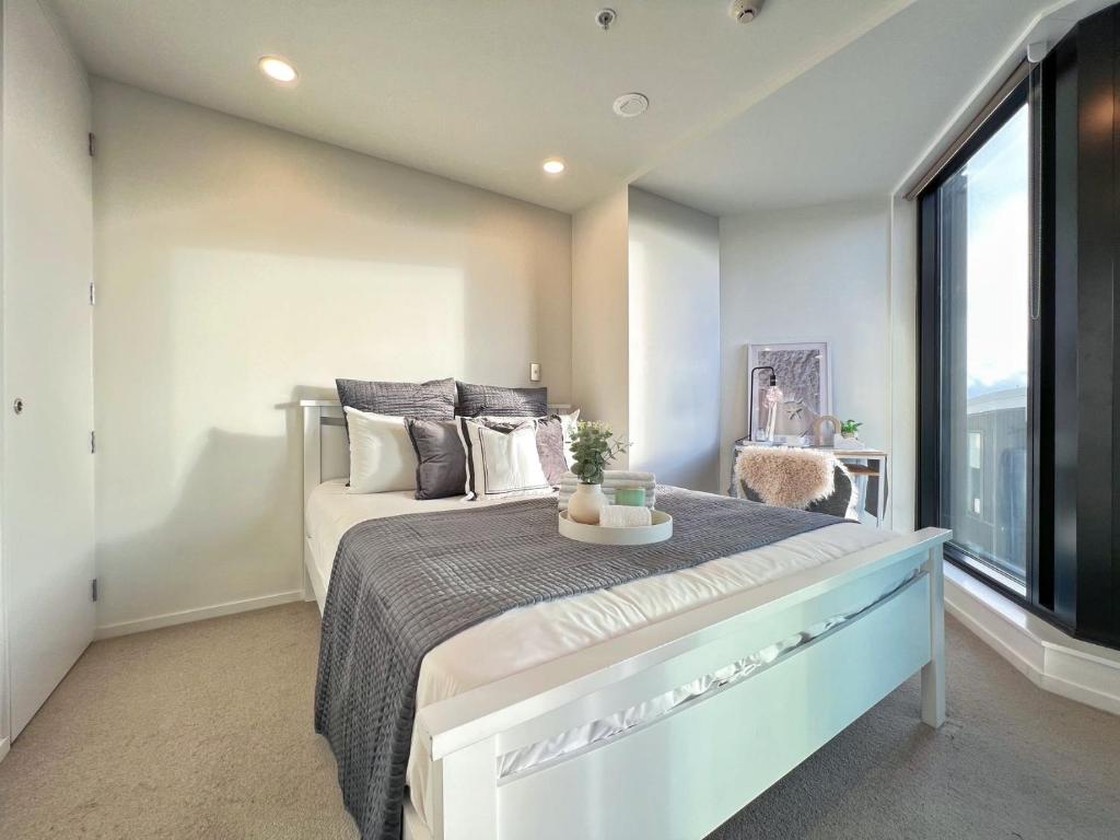 オークランドにあるStylish two-bedroom apartment in the city centerのベッドと大きな窓のある寝室