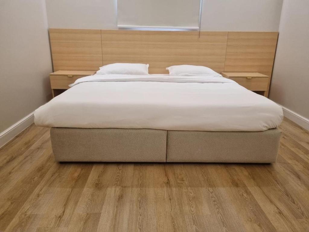 Una cama grande en un dormitorio con suelo de madera. en دار داكن للشقق المخدومة اقتصادي, en Riad
