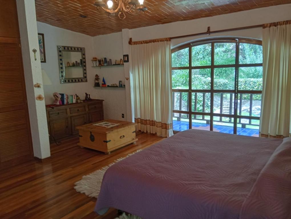een slaapkamer met een bed en een groot raam bij La Rinconada VIP in Mineral del Chico
