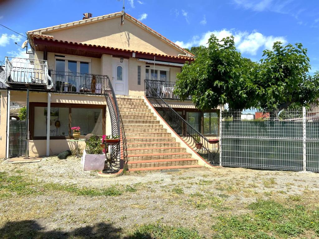 une maison avec un escalier en face de celle-ci dans l'établissement Appartement dans maison au 1er étage avec terrasse jardin ombrage et parking securise, à Béziers