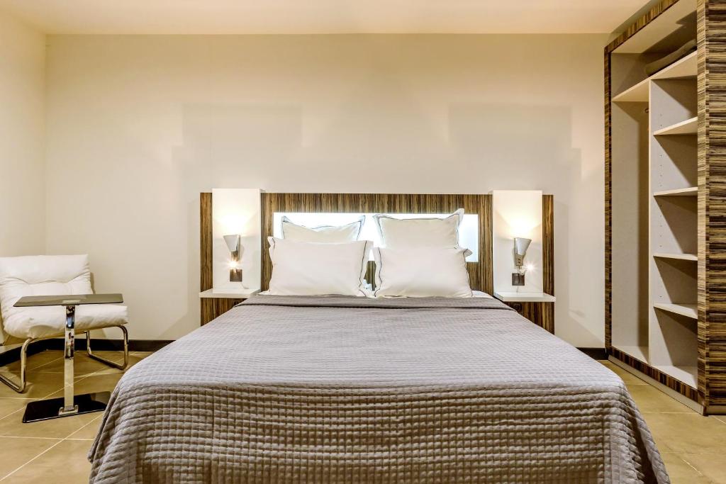 una camera da letto con un grande letto con cuscini bianchi di Residence Fort Savane a Fort-de-France