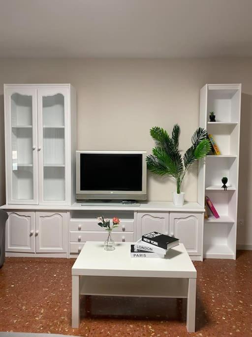 a living room with a white entertainment center with a tv at Apartamento vacacional playa in Almería