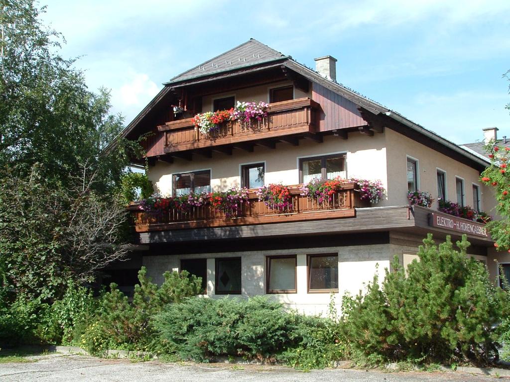 een gebouw met bloembakken op de balkons bij Ferienwohnung Hohengaßner in Mariapfarr
