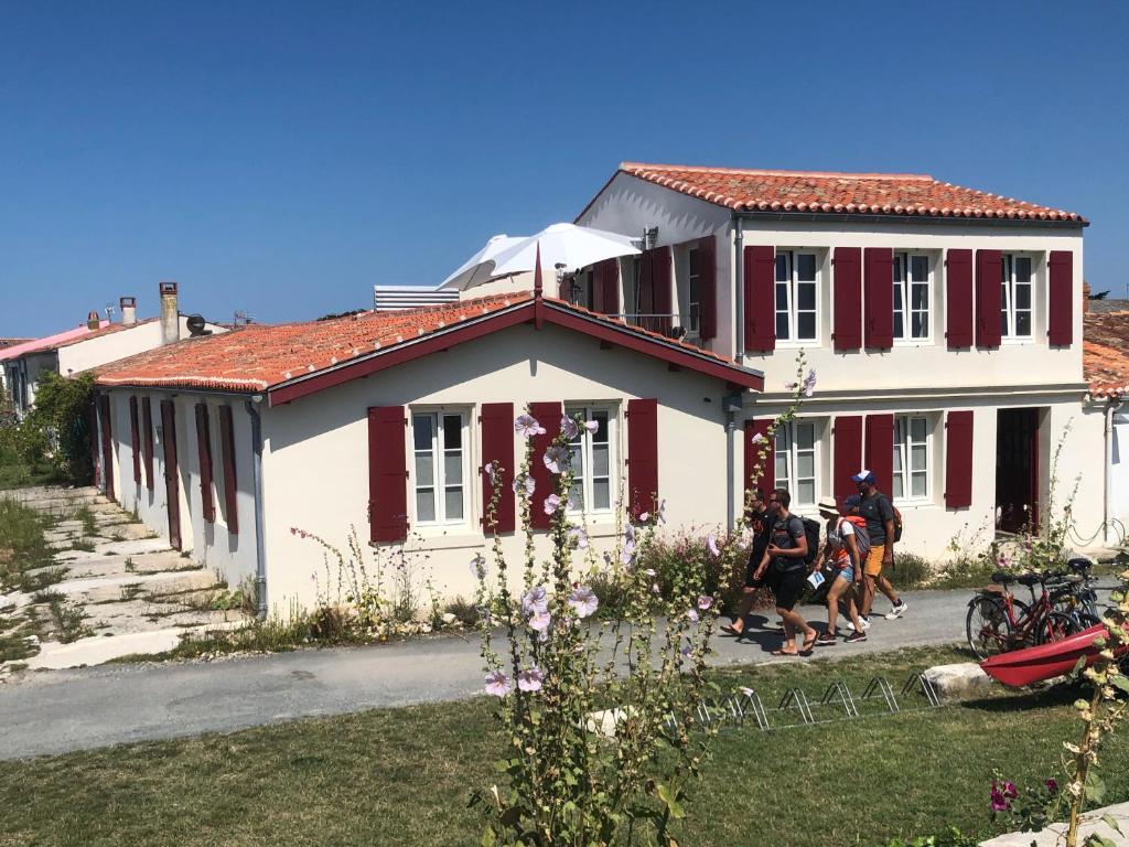 un groupe de personnes debout devant une maison dans l'établissement Escale Aixoise chambre privé, centre bourg, 50m de la mer, à Île-d'Aix