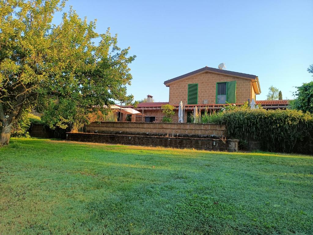 a house with a large yard with a grass field at Il Giardino nell'Orto in Vetralla