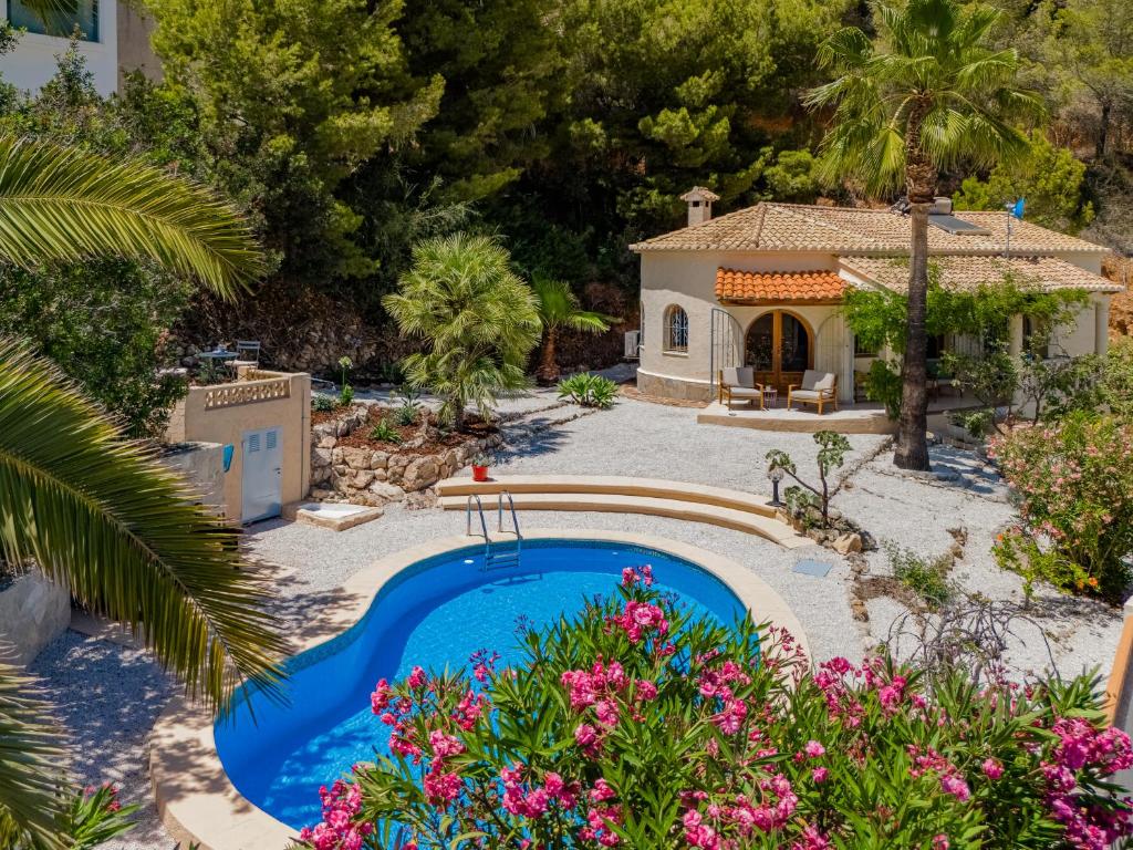 a backyard with a swimming pool and a house at Casa Coromandel in Calpe