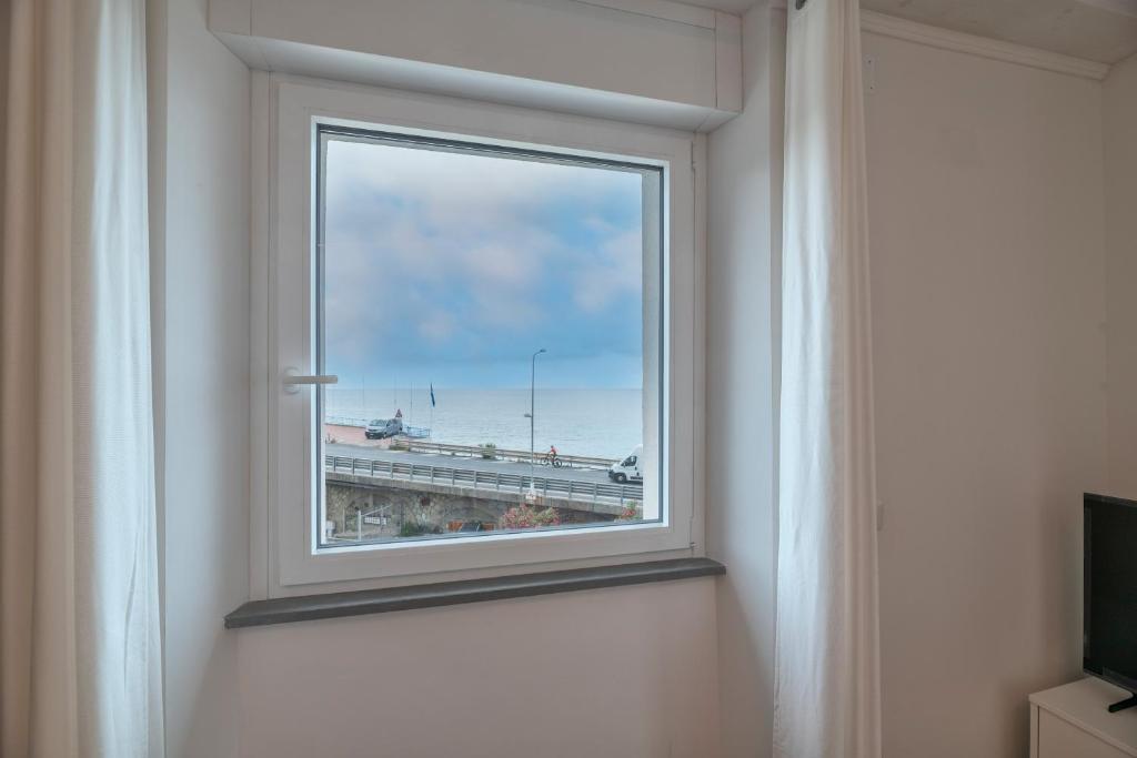 a window in a room with a view of a highway at VILLA CADIZ APARTMENTS VARAZZE in Varazze