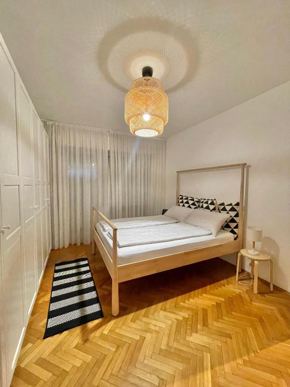 sypialnia z łóżkiem i żyrandolem w obiekcie Residenza XXX Aprile w Meranie