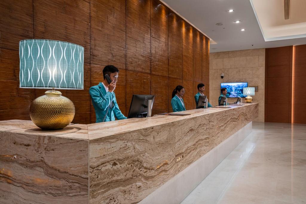 A polished reception desk with staff in a warmly lit hotel lobby.