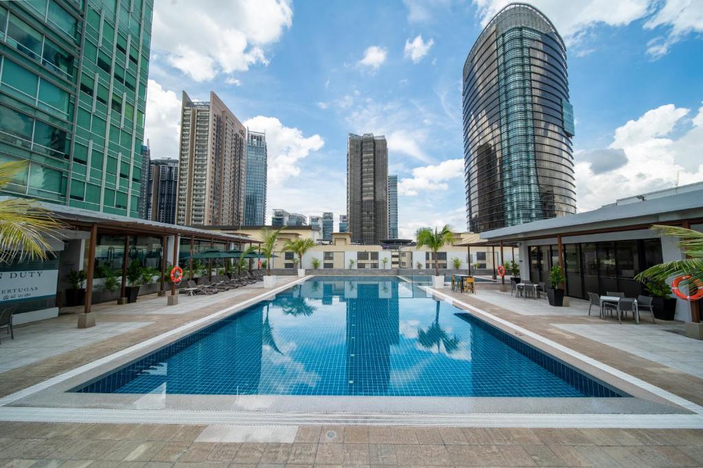 A rooftop-style outdoor pool framed by Kuala Lumpur high-rises.