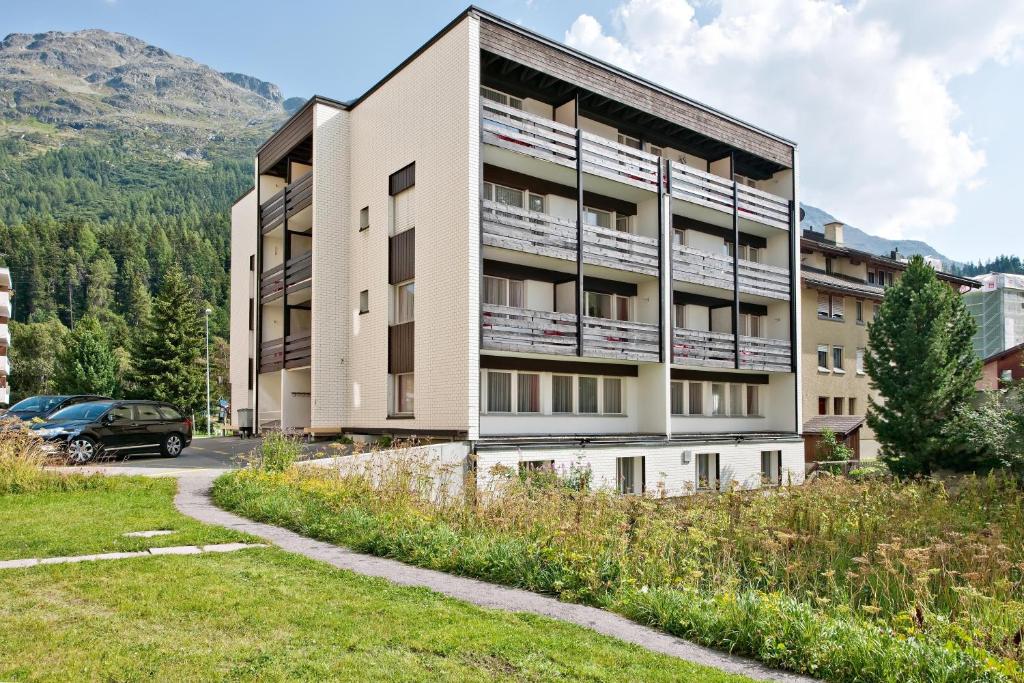 an apartment building with a car parked in front of it at Hostel Casa Franco in St. Moritz