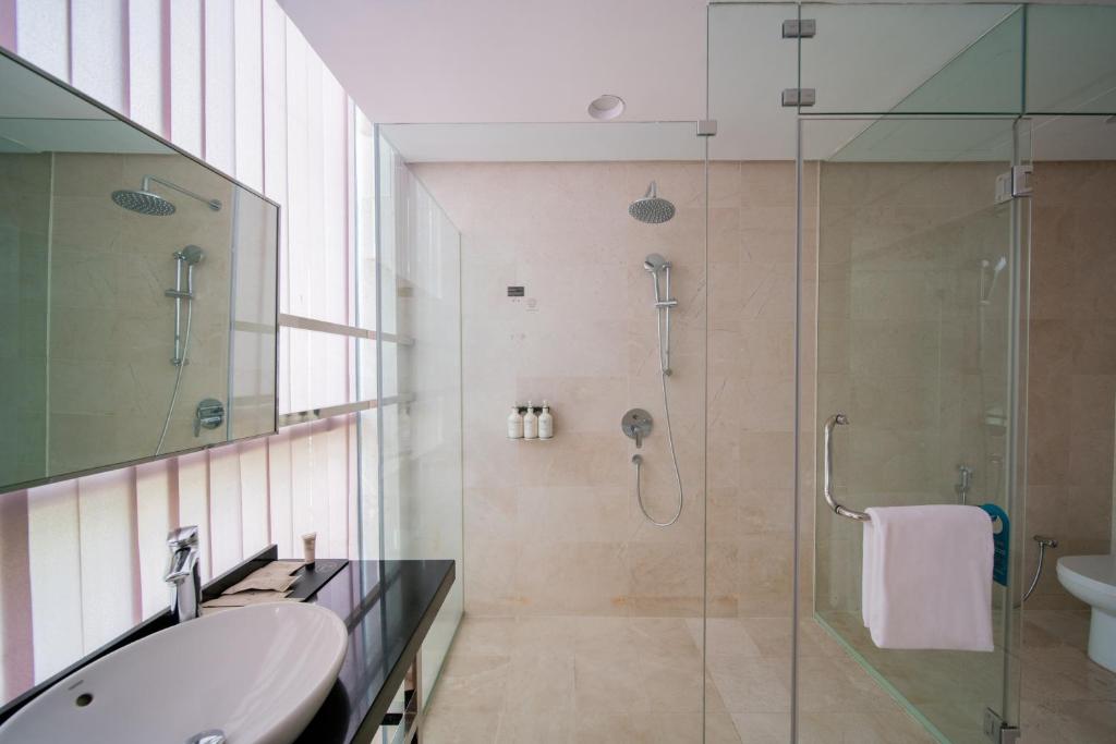 A marble-finished bathroom with a glass-enclosed walk-in shower.