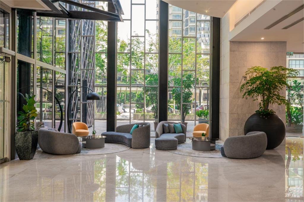 A bright lobby lounge with low upholstered seating beside tall windows.