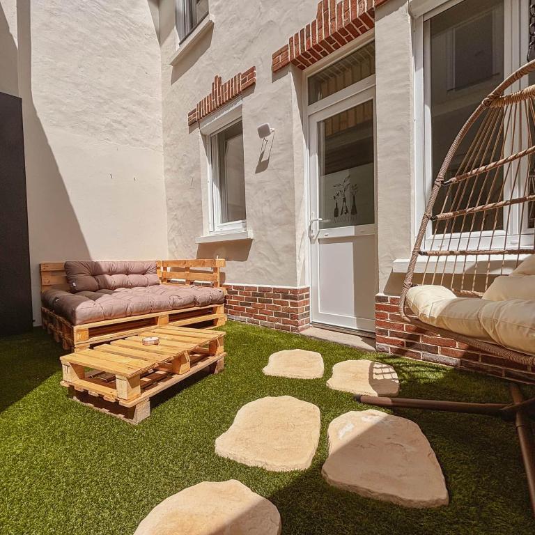 a backyard with a bird cage and some grass at La Casa Laura, Balnéo & Terrasse Privée in Étaples