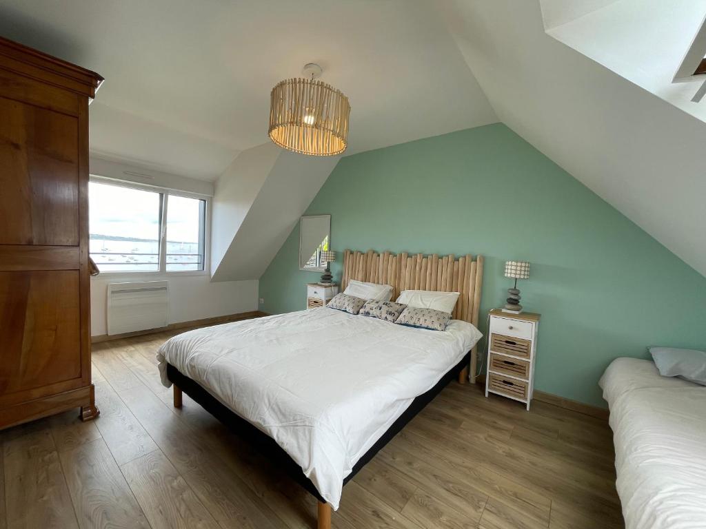 ein Schlafzimmer mit einem großen weißen Bett und einem Fenster in der Unterkunft Ar Parc Bihan, vue mer! in Audierne