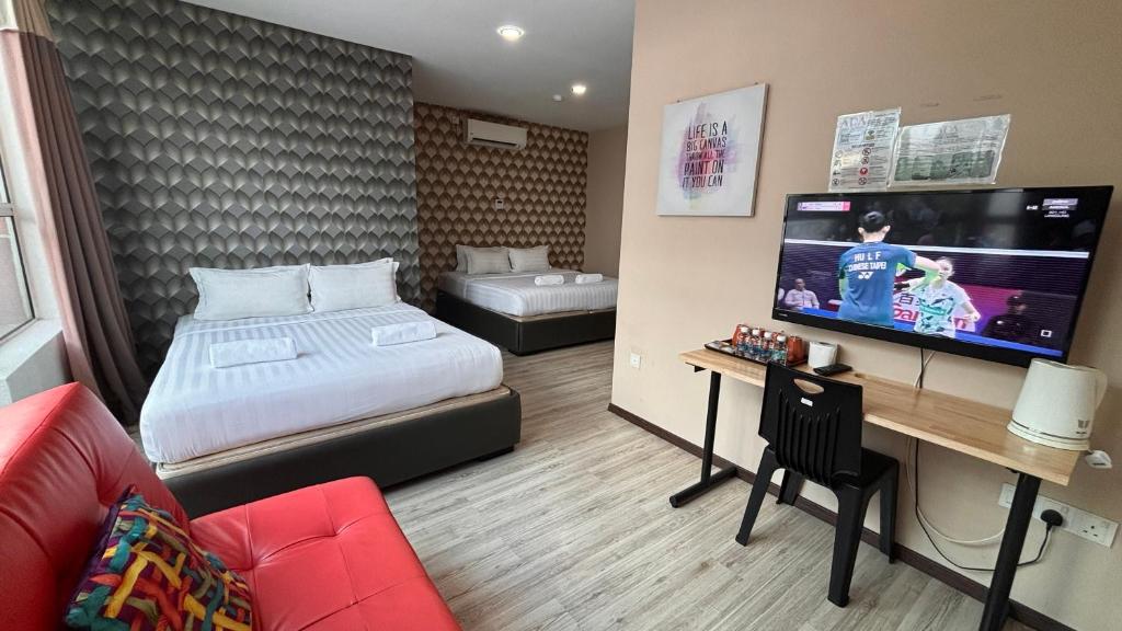瓜拉丁加奴Ada Hotel & Apartment的一间配有床和平板电视的酒店房间