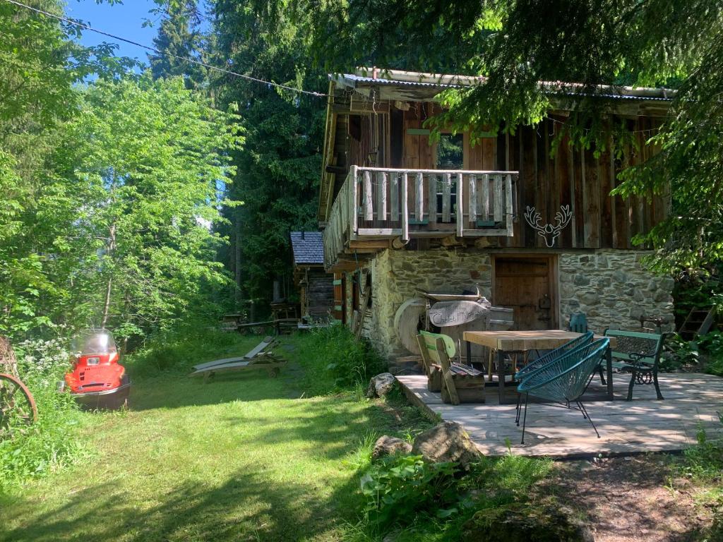 a log cabin with a deck and a table and chairs at Chalet F'Net in Saint-Gervais-les-Bains