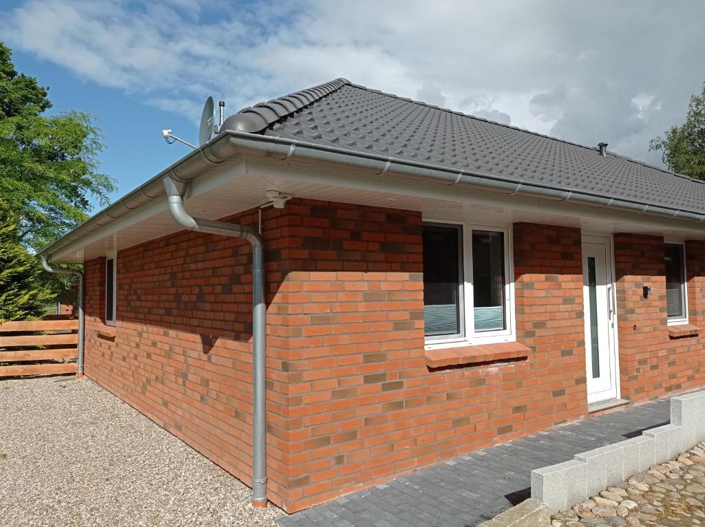 una casa de ladrillo rojo con techo inclinado en Ferienhaus Ebsen HH 1, en Steinberg