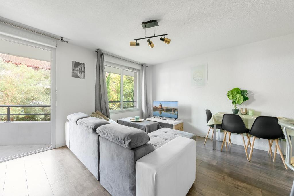 un salon avec un canapé et une table dans l'établissement T3 parking gratuit, balcon et résidence sécurisée, à Toulouse