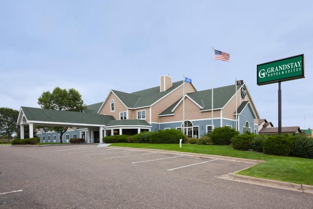 una casa grande con un letrero de la calle delante de ella en GrandStay Hotel & Suites - Stillwater, en Stillwater