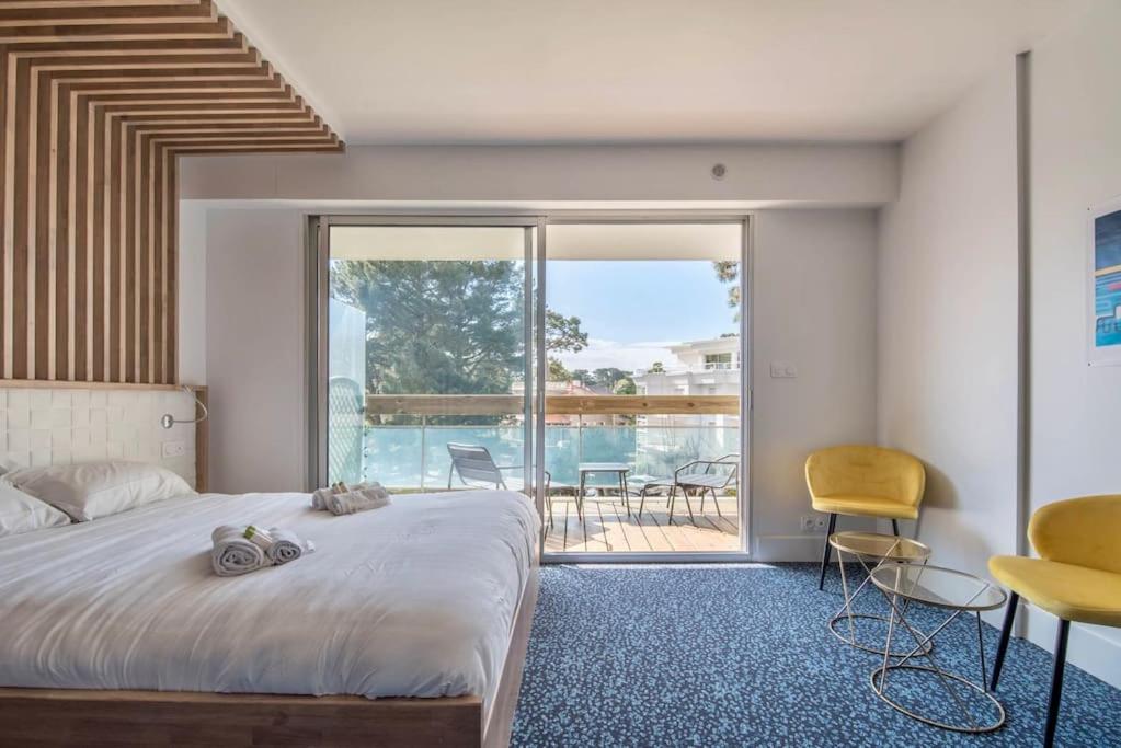 une chambre avec un grand lit et un balcon dans l'établissement Le Josselin Baulois, à La Baule