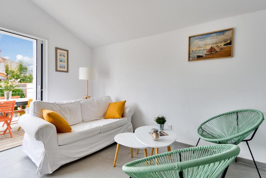 a living room with a couch and a table and chairs at 500m de la plage - Maison 6 adultes & 1 enfant in Barbâtre