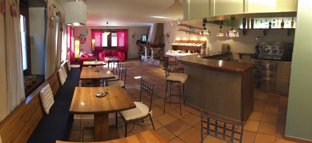 un restaurante con mesas de madera y un bar en Peira Blanca Hotel Gastronómico en Garós