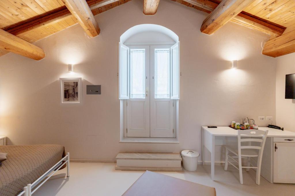 a bedroom with a bed and a desk in a room at Il Belvedere in Matera