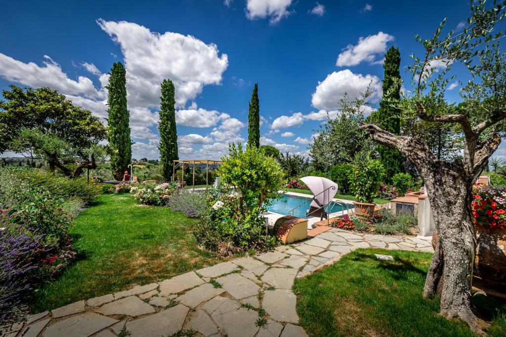 a garden with a swimming pool and trees at Villa dei Pavoni - B&B in Montauto