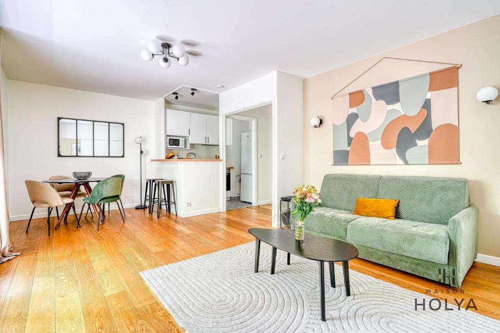 un salon avec un canapé vert et une table dans l'établissement Le Verdoyant - À Auteuil - 312B, à Paris