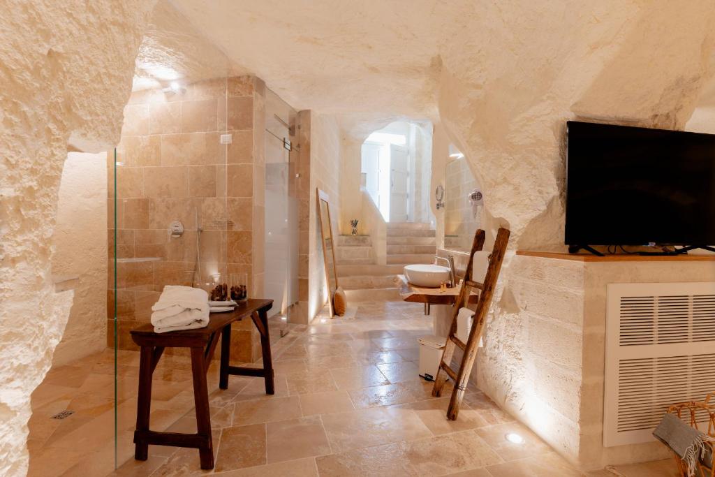 a bathroom with a shower and a tv on a stone wall at Il Belvedere in Matera