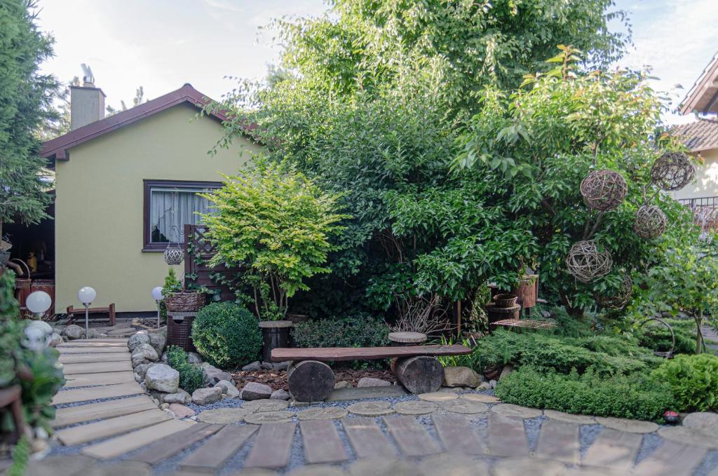 a garden with a bench in front of a house at Domek Letniskowy Pucka in Mieroszyno