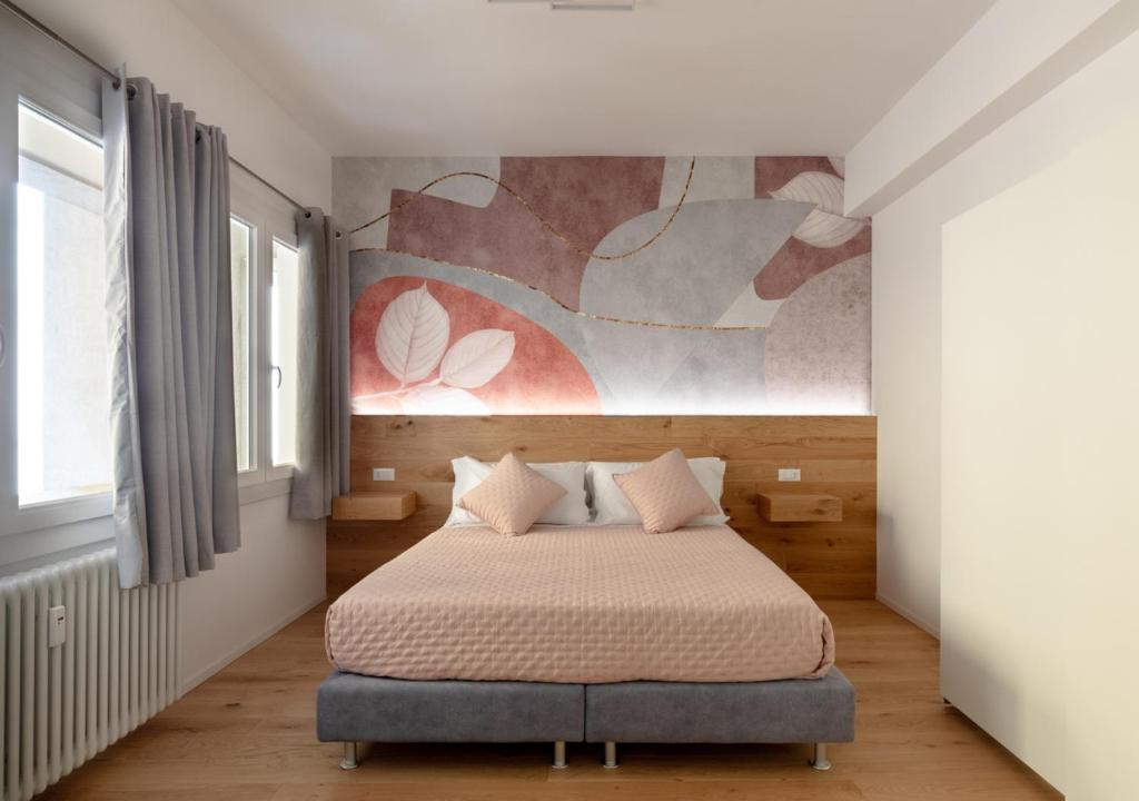 a bedroom with a bed and a painting on the wall at Fully Furnished Pink Apartment 2 in Treviso
