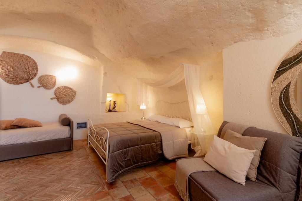 a hotel room with two beds and a couch at Il Belvedere in Matera