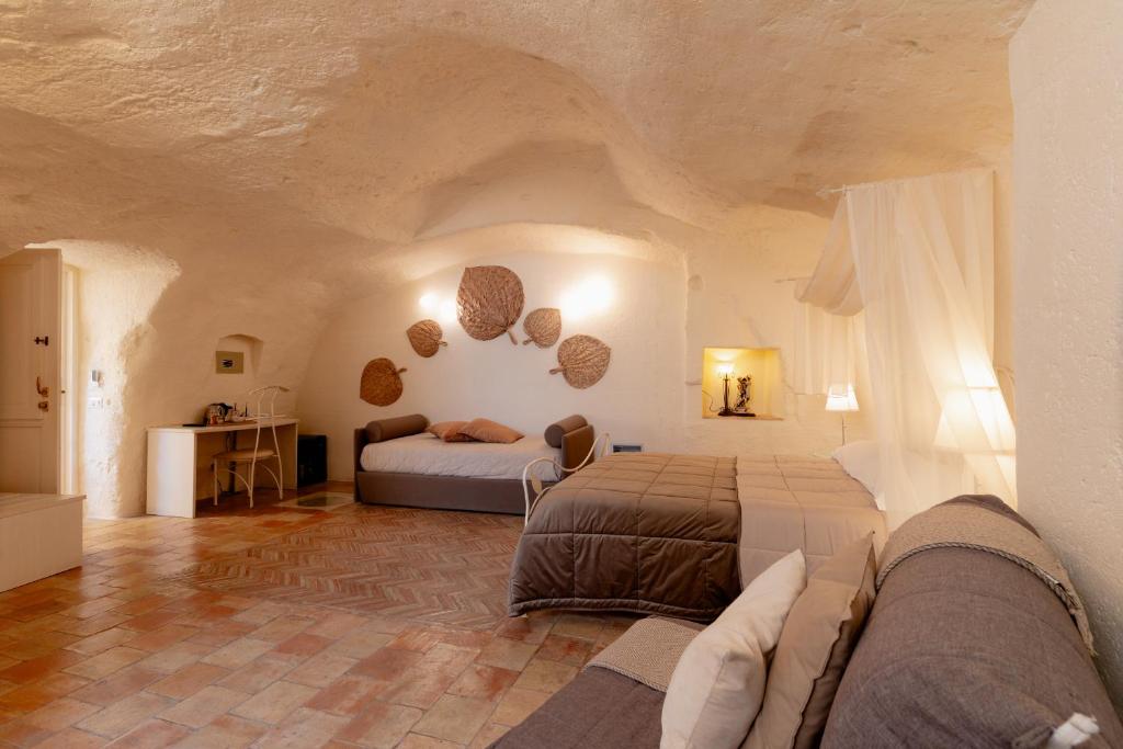 a bedroom with two beds and a couch in a room at Il Belvedere in Matera