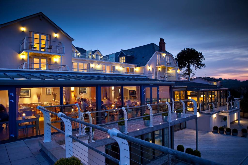 a resort with a pool and a restaurant at night at St Brides Spa Hotel & Village Apartments in Saundersfoot
