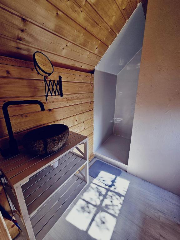 a room with a wooden wall and a bowl on a table at Camping à la ferme - Hébergements insolites in Cerisy-la-Forêt