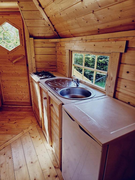 a kitchen with a sink in a log cabin at Camping à la ferme - Hébergements insolites in Cerisy-la-Forêt