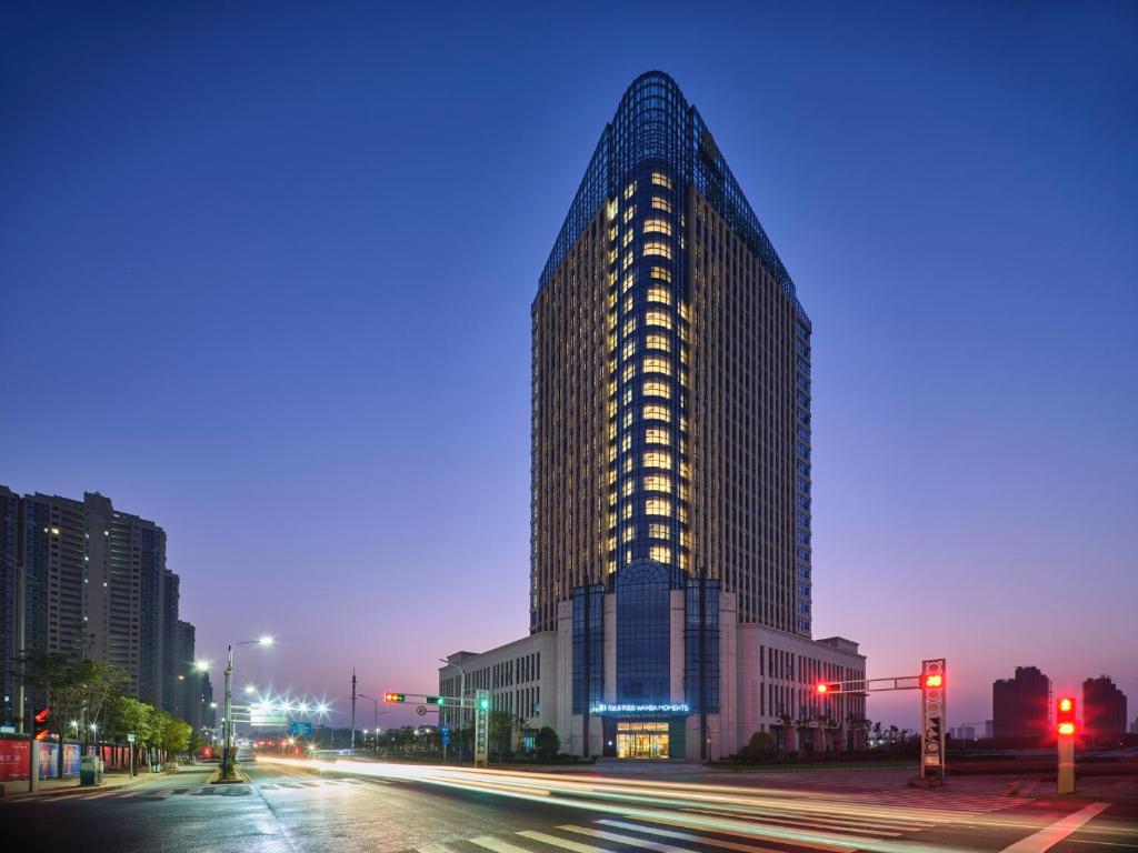 a tall building on a city street at night at Wanda Moments Nanchang in Xinjian