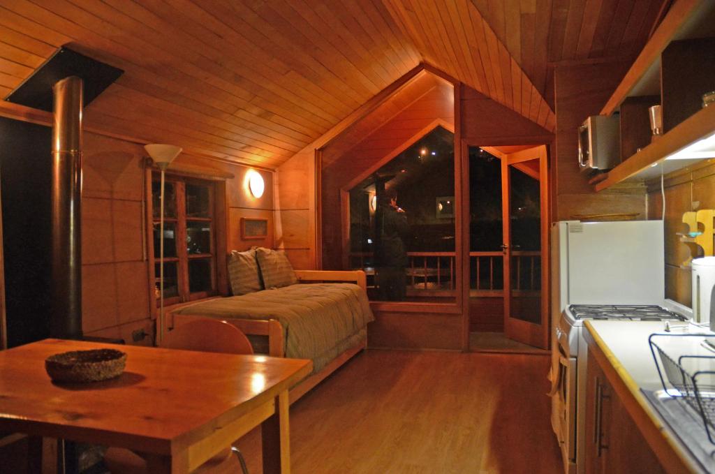 a kitchen with a bed and a table in a room at Palafito Azul Apart Hotel in Castro