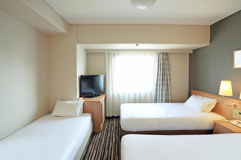Postel nebo postele na pokoji v ubytování Smile Hotel Tokushima