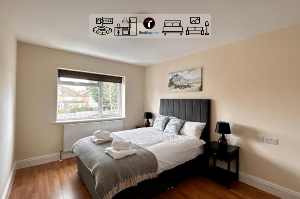 a bedroom with a large bed and a window at Stylish 2 Bedroom Flat By Tara Stays Short Lets & Serviced Accommodation Watford With Free Parking & Nearby Warner Studios in Watford