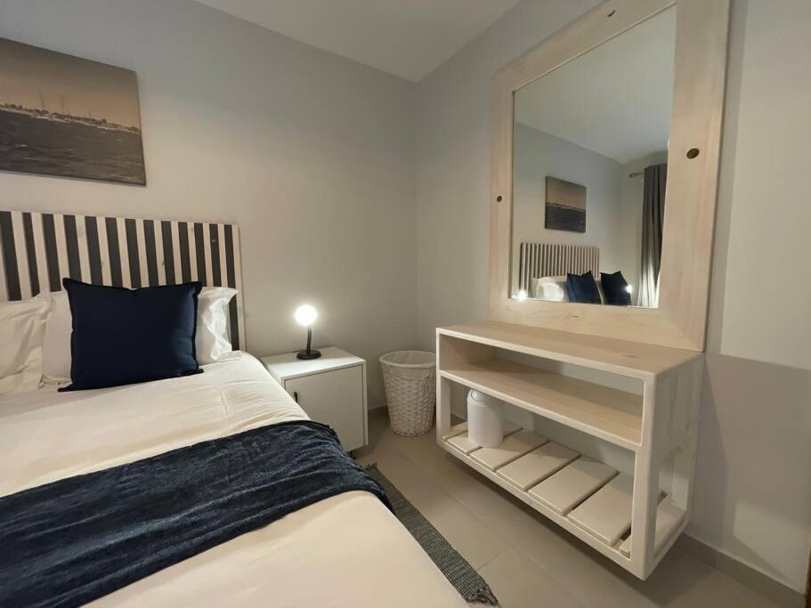 une chambre avec un lit et un grand miroir dans l'établissement Central Apartment at Bismarck5, à Swakopmund