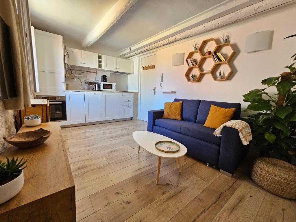 un salon avec un canapé bleu et une table dans l'établissement Charmant 2 pièces au cœur du Vieil Antibes, à Antibes