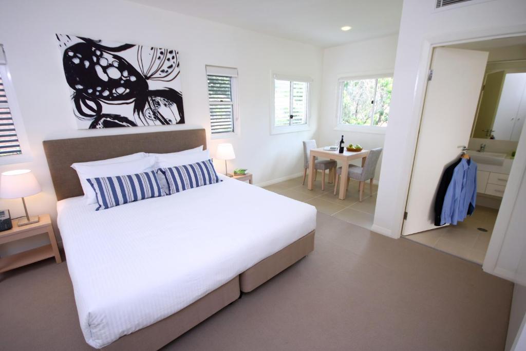 a bedroom with a large bed and a bathroom at Domain Serviced Apartments in Brisbane