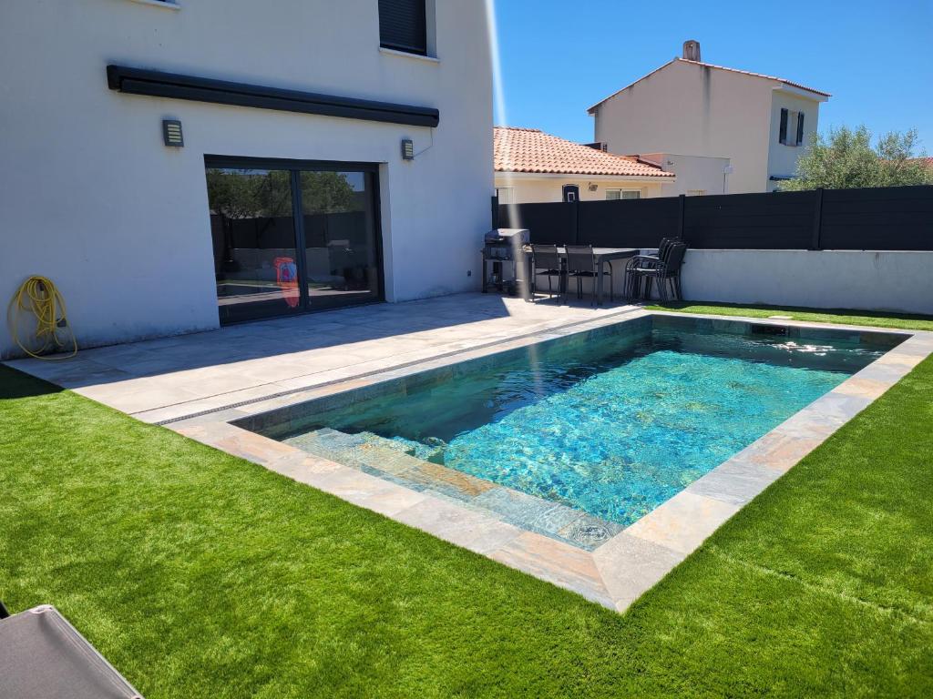une piscine dans l'arrière-cour d'une maison dans l'établissement Maison avec piscine, à Saint-Mathieu-de-Tréviers