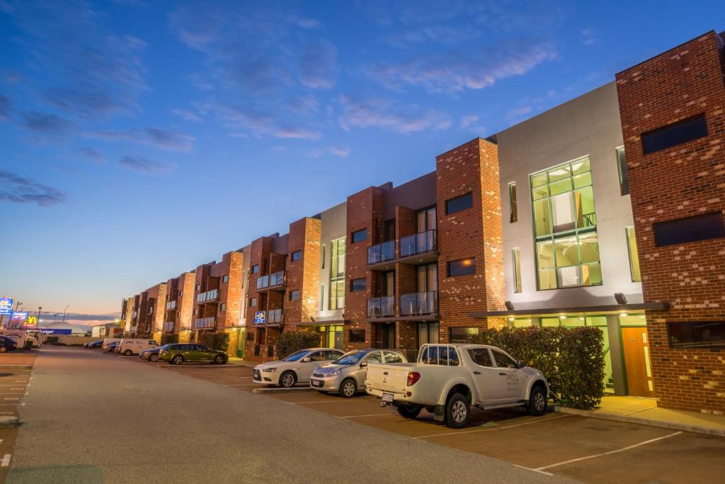 een rij gebouwen met auto's geparkeerd op een parkeerplaats bij Perth Ascot Central Apartment Hotel Official in Perth