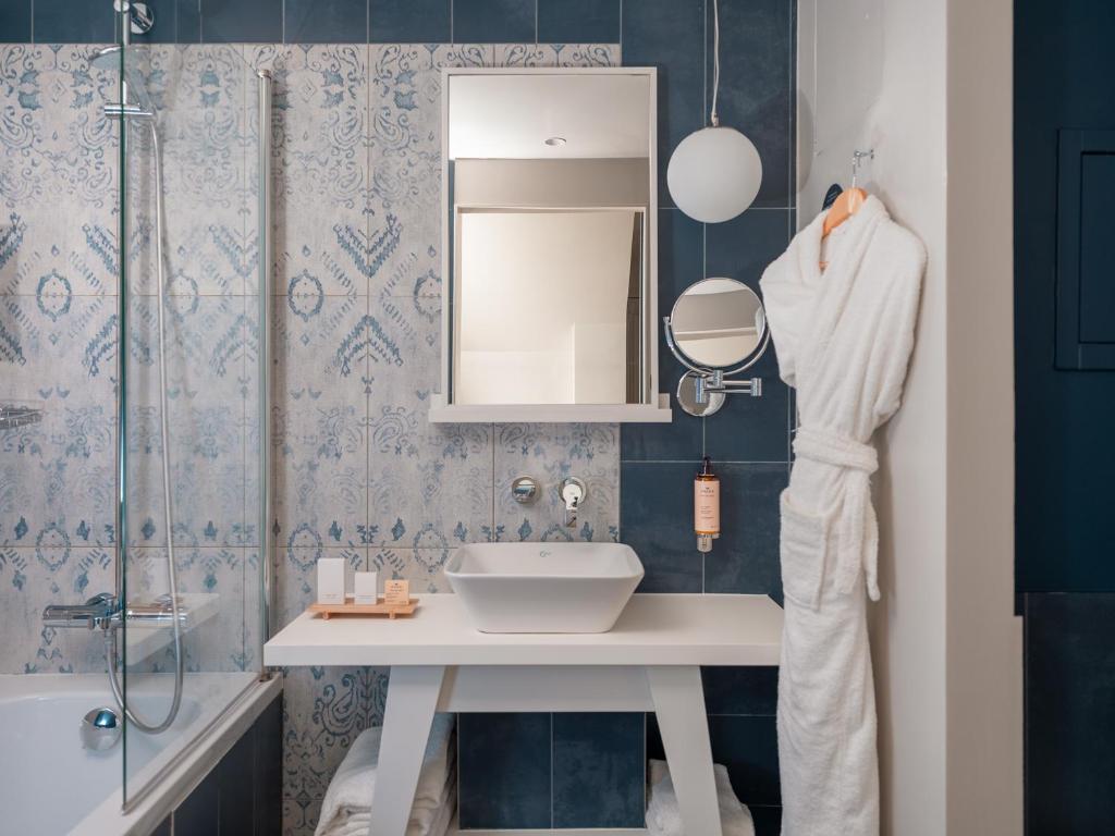 a bathroom with a sink and a mirror and a shower at Hotel Belleval in Paris