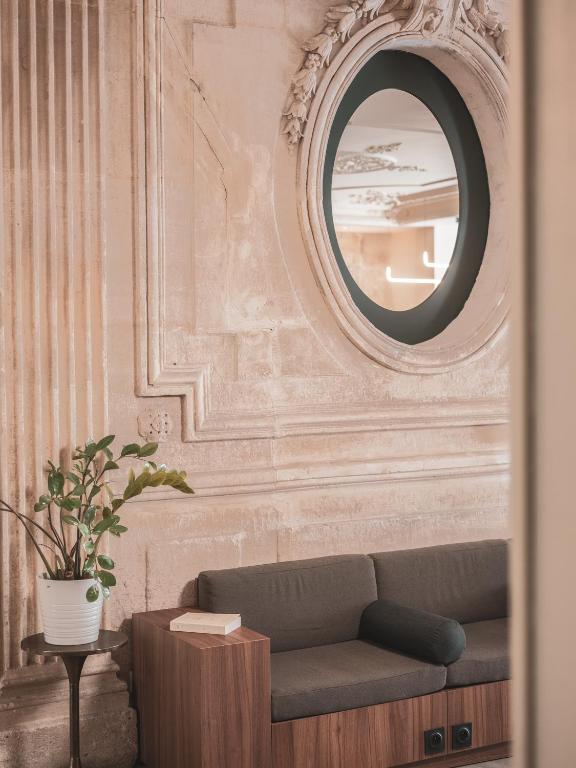 a living room with a couch and a mirror at Hotel Belleval in Paris